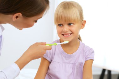 Diş hekiminde dişçi ve küçük kız.