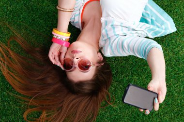 güzel ve genç birbayan yeşil çim yalan onu telefonla selfie yapma