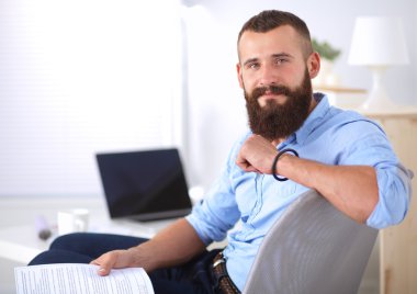 Genç işadamı koltukta oturuyor.