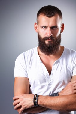 Ayakta, gri arka plan üzerinde izole yakışıklı adam portresi