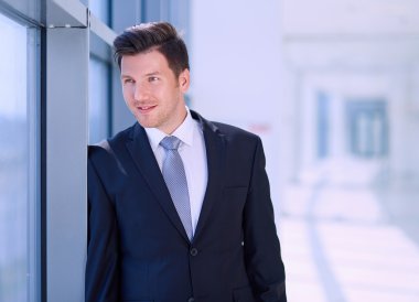 Ofisteki pencerenin yanında duran işadamının portresi