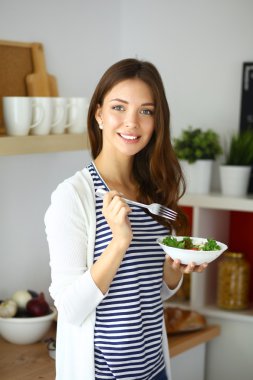 Salata yemek ve karışık salata tutan genç kadın