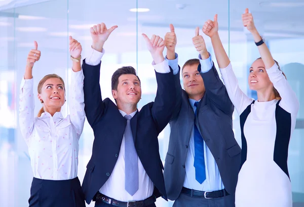 Happy business team showing thumbs up in office — Stock Photo, Image