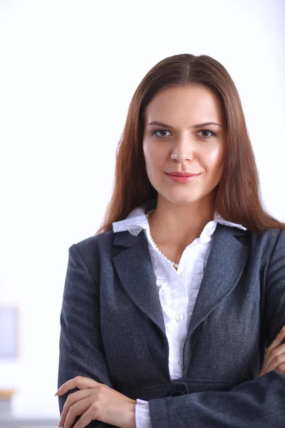 Attractive young businesswoman standing near desk in the office — Stock Photo, Image