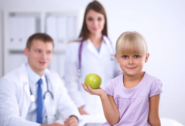 Child and medicine concept - female doctor giving an apple to little girl — Stock Photo, Image