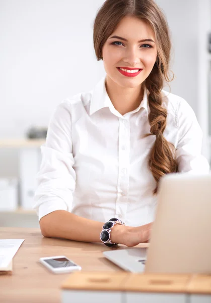 Attraktive Geschäftsfrau sitzt auf Schreibtisch im Büro — Stockfoto