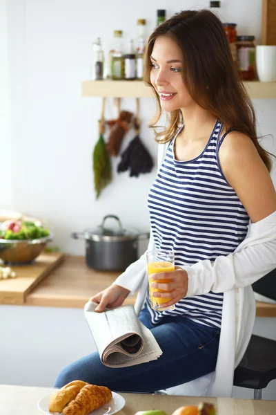 Porträtt av en vacker kvinna som sitter i köket — Stockfoto