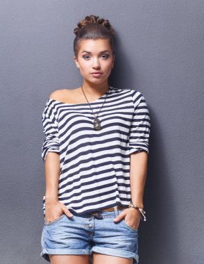 ayakta, gri arka plan üzerinde izole genç kadın