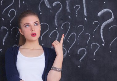 soru işareti gri bir arka plan üzerinde bulunan genç kız