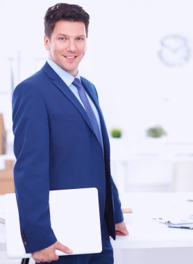 Ofiste masasının karşısında duran bir iş adamı ya da yönetici.