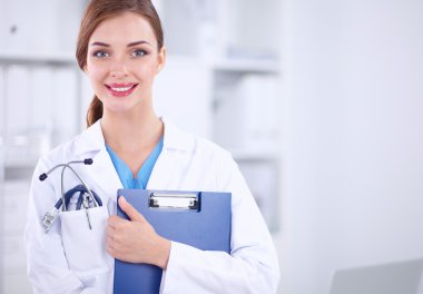 Hastanede üniformalı, gülümseyen bir kadın doktor.