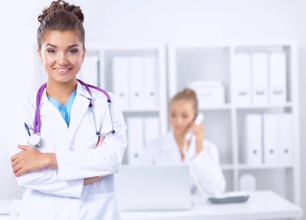 Retrato de una joven doctora con una bata blanca de pie en el hospital — Foto de Stock