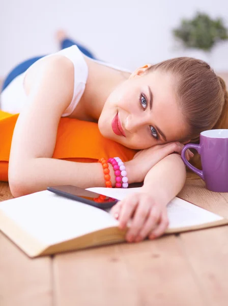 Mujer joven sonriente acostada en un suelo blanco con almohada — Foto de Stock