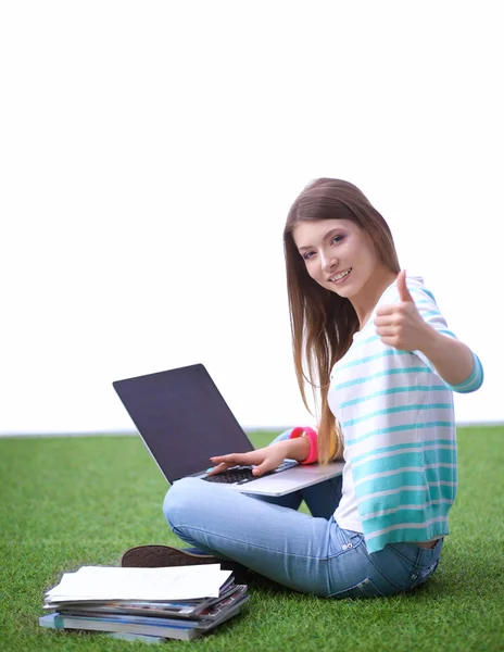 Young woman with laptop sitting on green grass — Stock Photo, Image