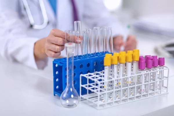 Woman researcher is surrounded by medical vials and flasks, isolated on white background — Stock Photo, Image