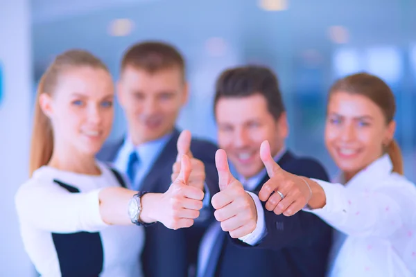 Feliz equipo de negocios mostrando pulgares hacia arriba en la oficina — Foto de Stock