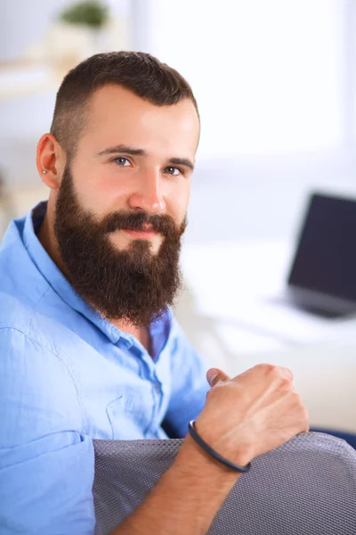 Jonge zakenman zit op stoel in functie — Stockfoto