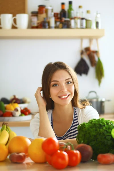 Jonge vrouw zit in de buurt van bureau in de keuken — Stockfoto