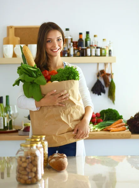 Молода жінка тримає продуктовий сумку з овочами — стокове фото