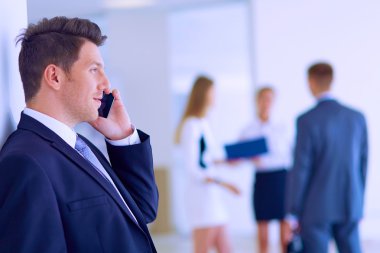 arka planda meslektaşları ile Office genç işadamı portresi