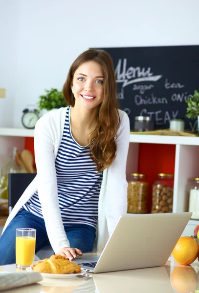 Portrait of a pretty woman sitting in the kitchen — Stock Photo, Image
