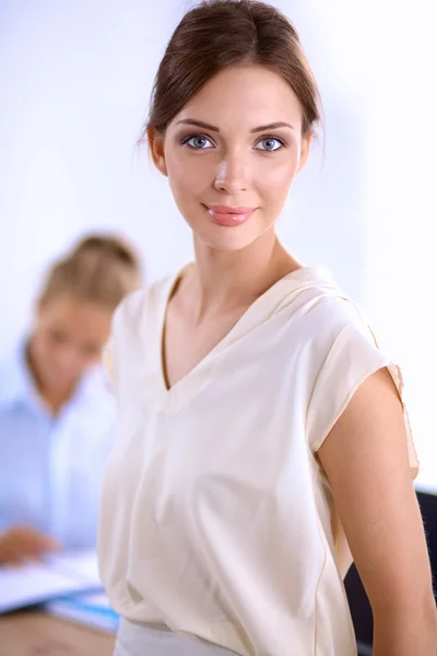 Attraktive Geschäftsfrau steht an Wand im Büro — Stockfoto