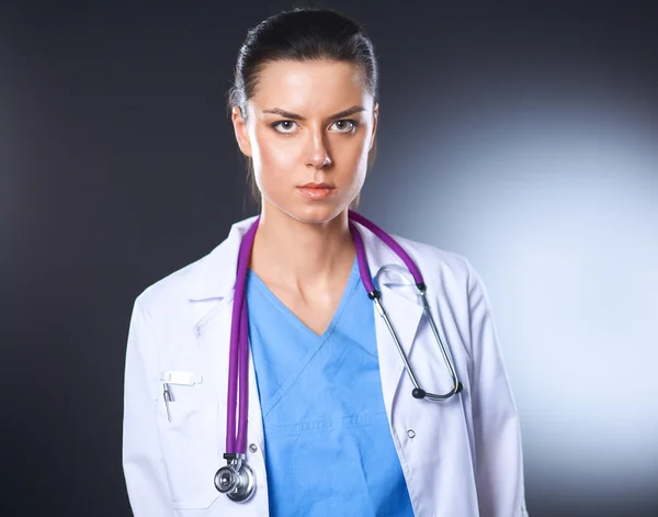 Jeune médecin femme avec stéthoscope isolé sur gris — Photo