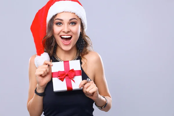 Donna in cappello Babbo Natale in possesso di doni, isolato su grigio — Foto Stock