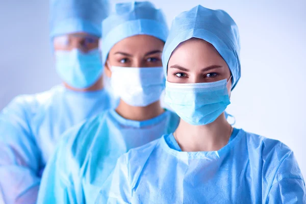 Chirurgen team, dragen beschermende uniformen, petten en maskers — Stockfoto