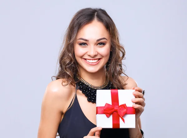 Young woman happy smile hold gift box in hands, isolated over grey background — Stock Photo, Image