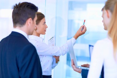 Toplantı sırasında dizüstü bilgisayarla sunum yapan bir grup iş adamı