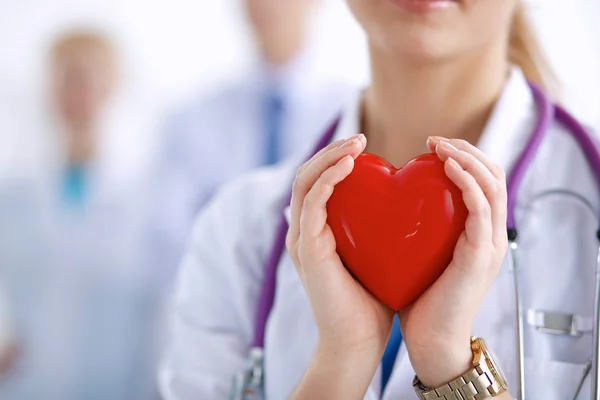 Female doctor with stethoscope holding heart — Stock Photo, Image