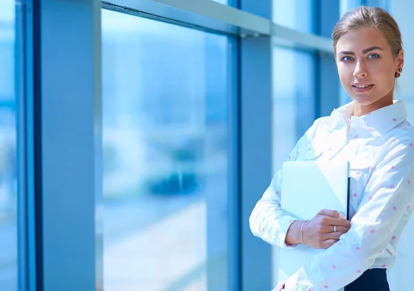 Бизнесмен, стоящая у окна офиса с документами в руках — стоковое фото
