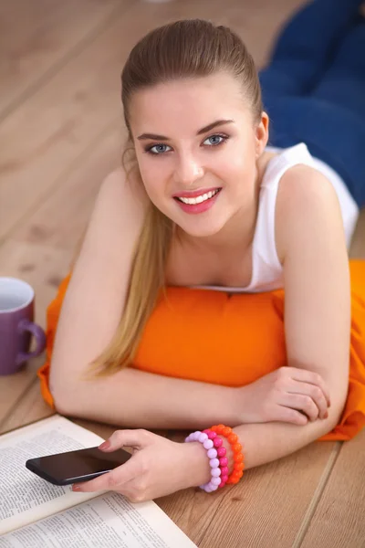 Sorrindo jovem deitada em um chão branco com travesseiro — Fotografia de Stock