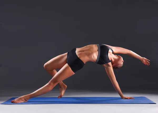 Porträtt av sport flicka gör yoga stretching motion — Stockfoto