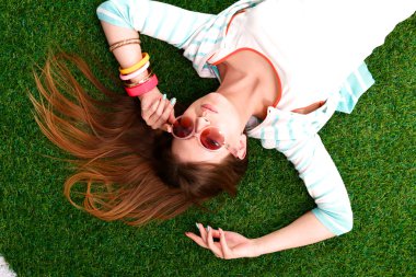 güzel bir genç kadın yeşil çim üzerinde yalan