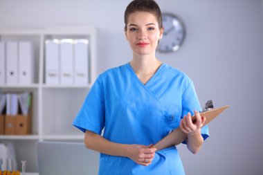 Hastanede üniformalı, gülümseyen bir kadın doktor.