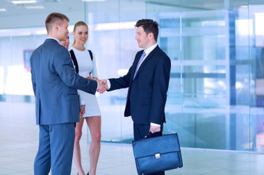 İki başarılı iş adamının el sıkışırken tam boy görüntüsü.
