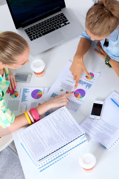 Dos mujeres trabajando juntas en la oficina, sentadas en el escritorio — Foto de Stock