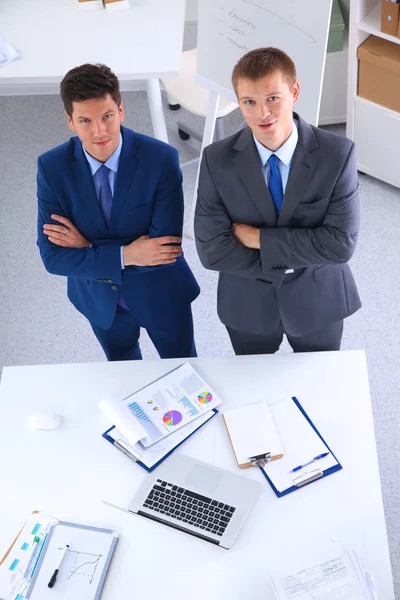 Dois empresários de pé com uma folha de papel em branco — Fotografia de Stock