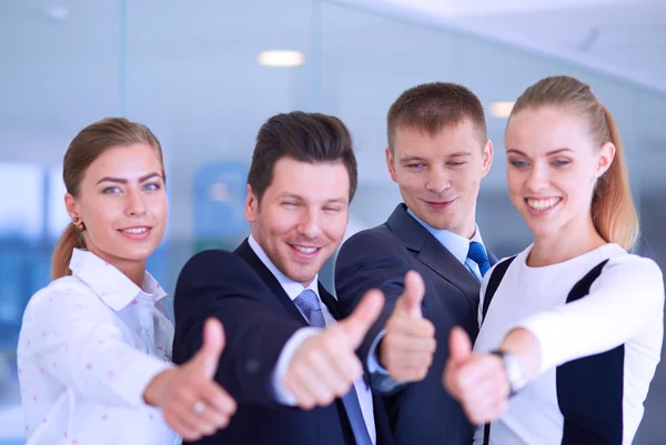 Feliz equipo de negocios mostrando pulgares hacia arriba en la oficina — Foto de Stock