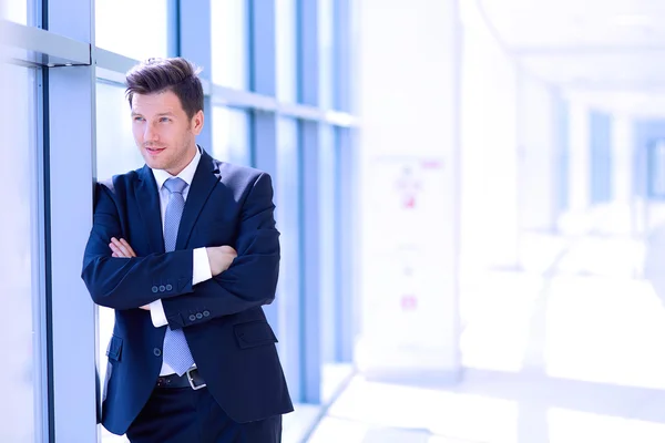 Retrato del hombre de negocios de pie cerca de la ventana en la oficina —  Fotos de Stock