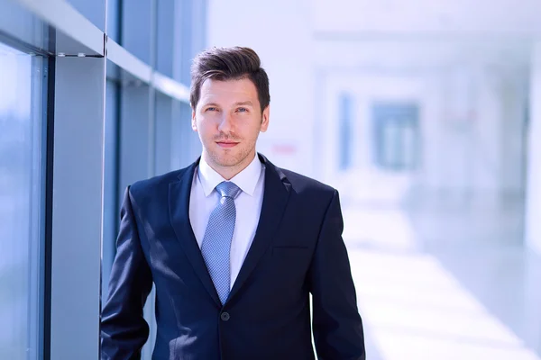 Portrait of businessman standing near window in office — Stock Photo, Image