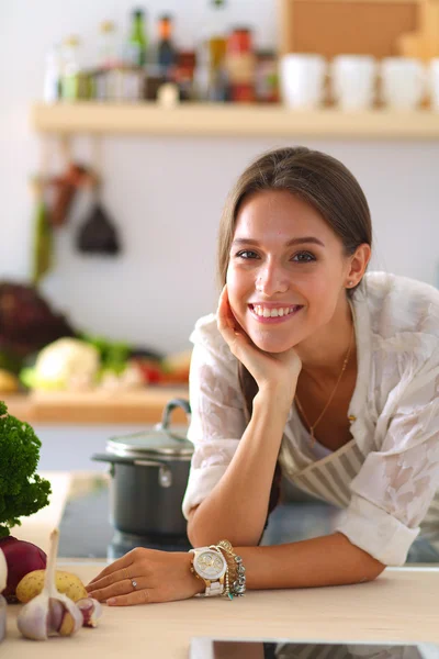 Jonge vrouw met behulp van een tablet computer om te koken in haar keuken — Stockfoto