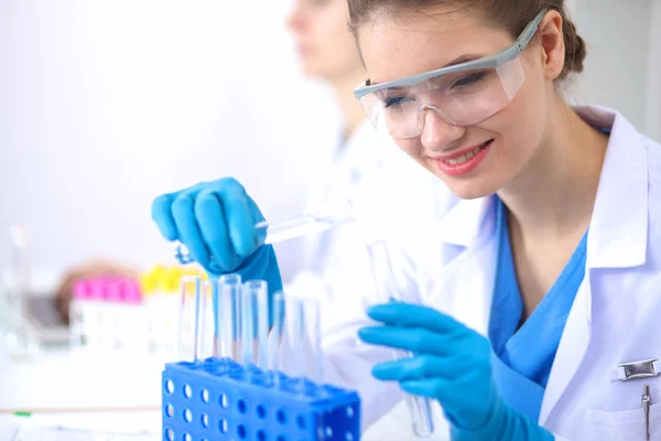 Woman researcher is surrounded by medical vials and flasks, isolated on white background Stock Image