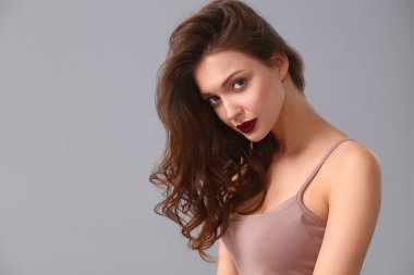 Gri arka planda izole edilmiş güzel bir kadının portresi.