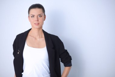 ayakta, gri arka plan üzerinde izole genç kadın