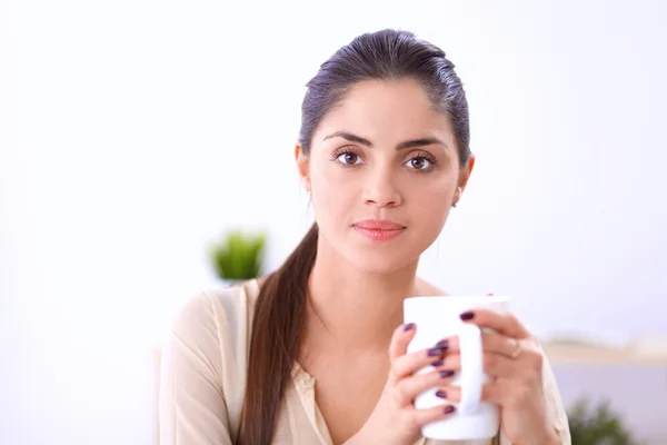 Красивая деловая женщина наслаждается кофе в светлом офисе — стоковое фото