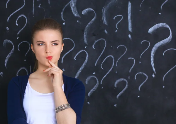 Young girl with question mark on a gray background — Stock Photo, Image