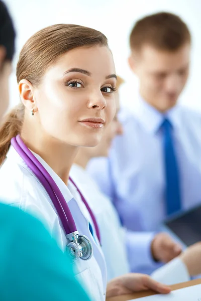 Attractive female doctor in front of medical group — Stock Photo, Image